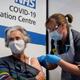 A nurse administers the Covid-19 vaccine to an elderly woman.